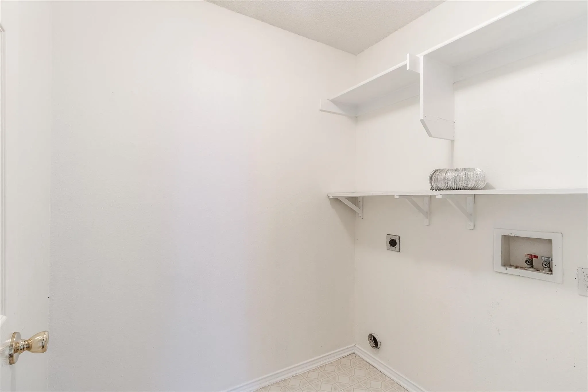 Built-in shelving for storage, wall-mounted connections for appliances, and patterned flooring