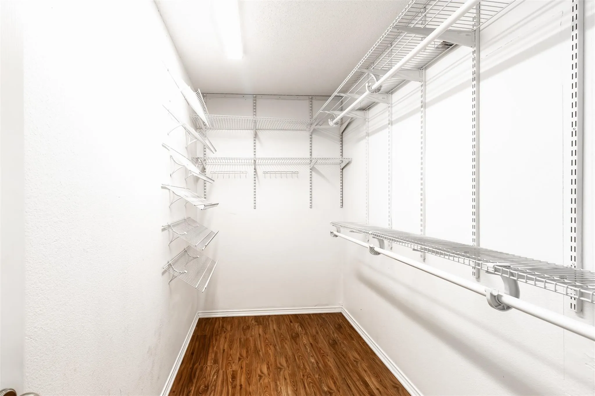 Recessed lighting illuminating the wood-finish flooring