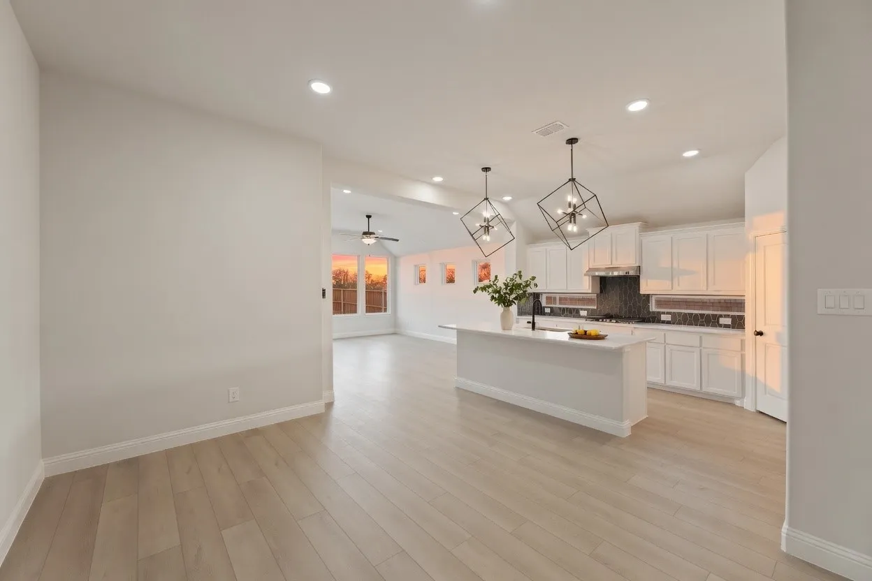 Wood-finish flooring, recessed lighting, vaulted ceilings, kitchen island with built-in sink, and pendant lighting