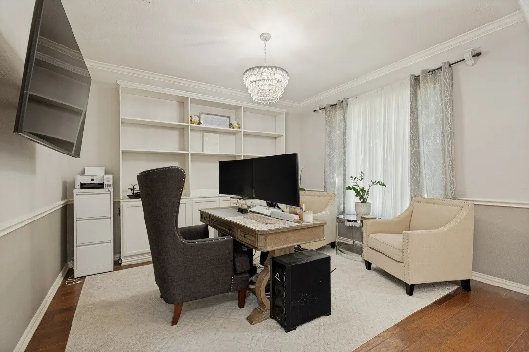 Dedicated home office with built-in shelving and cabinetry, designer lighting, and a functional workspace perfect for working from home.
