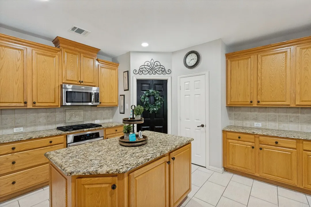 The oversized center island anchors the kitchen, providing the perfect space for meal prep, casual dining, and gathering with family and friends.
