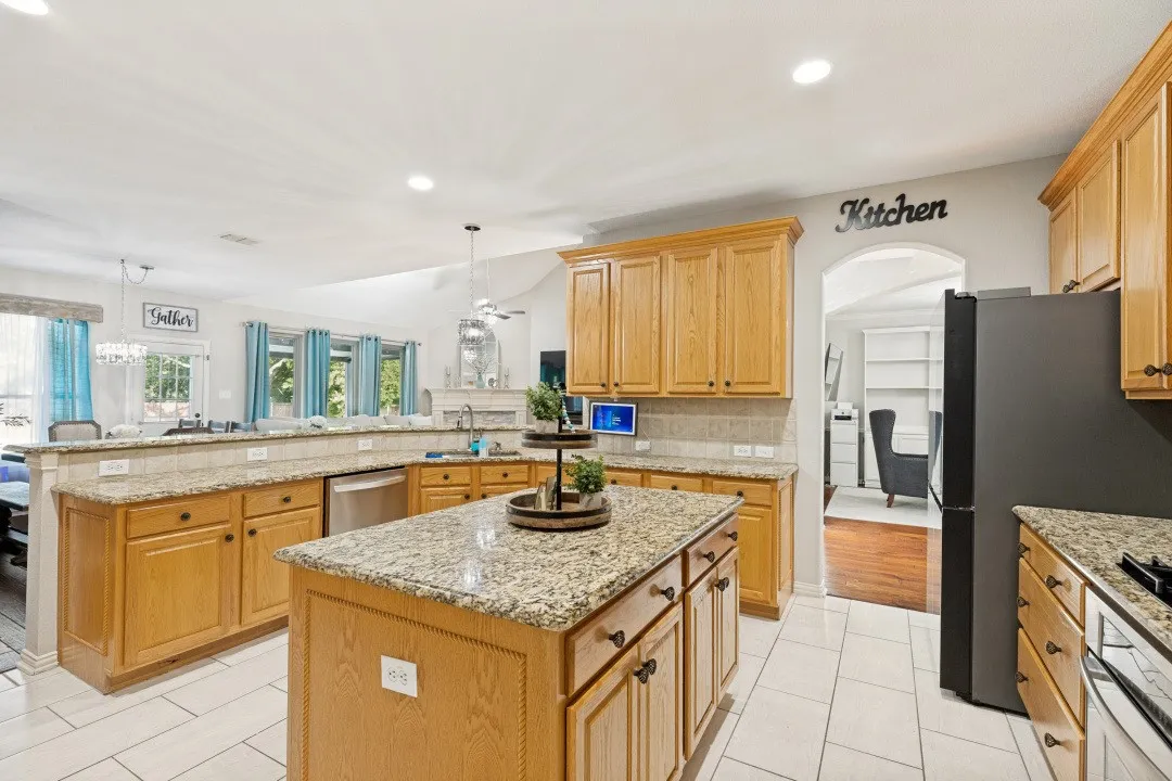 Well-appointed kitchen featuring granite countertops, a large center island, abundant cabinetry, and generous prep space.