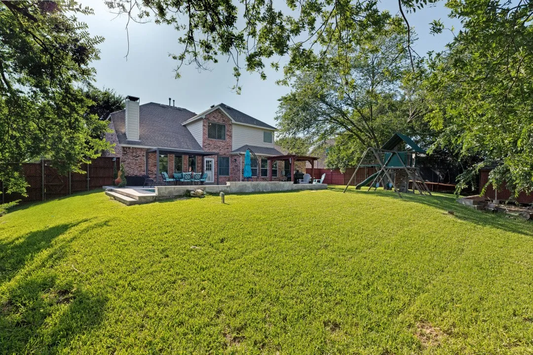 Oversized backyard with mature trees, expansive green space, and plenty of room to relax, entertain, or play.