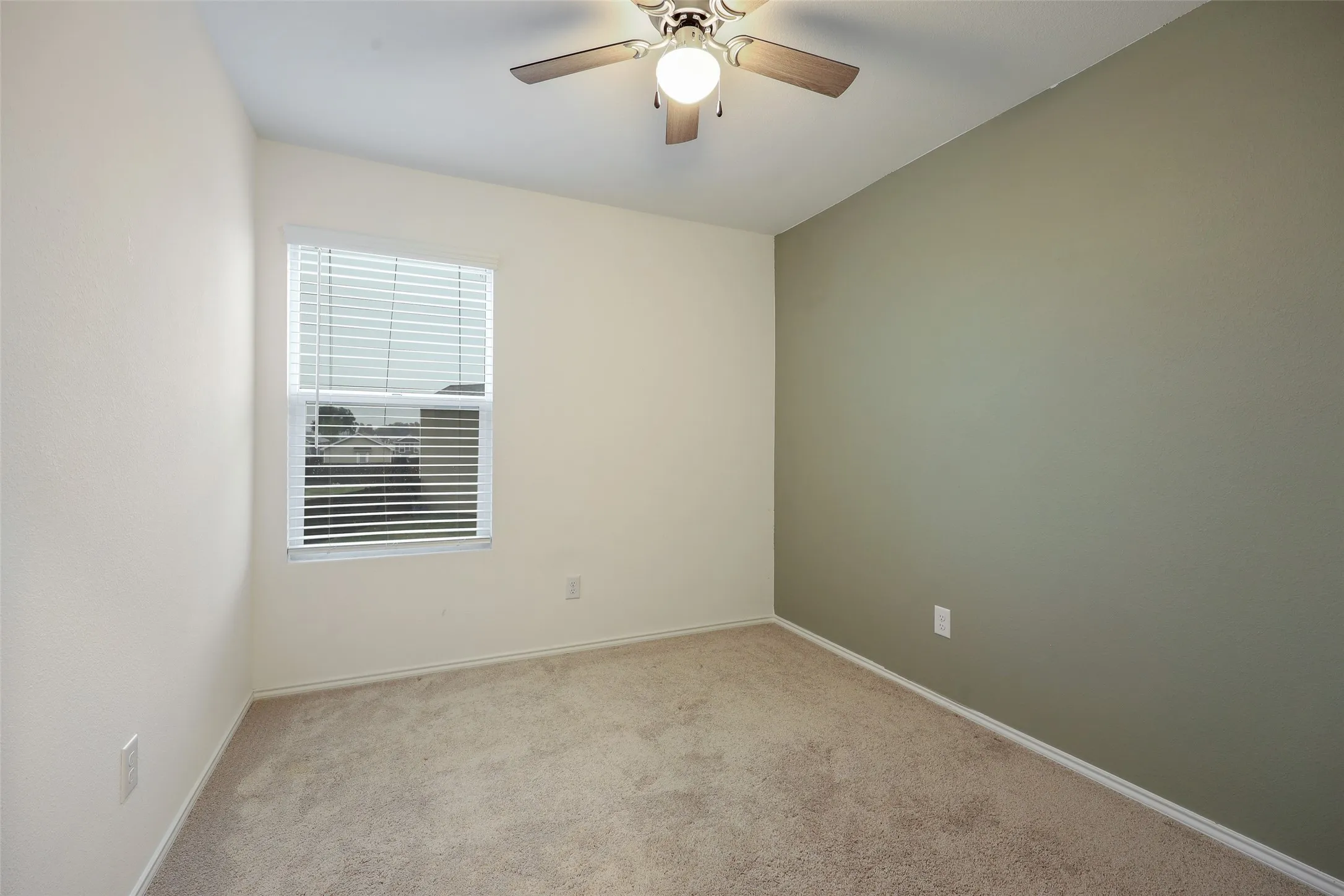 Wall-to-wall carpeting with painted walls and a single window with blinds
