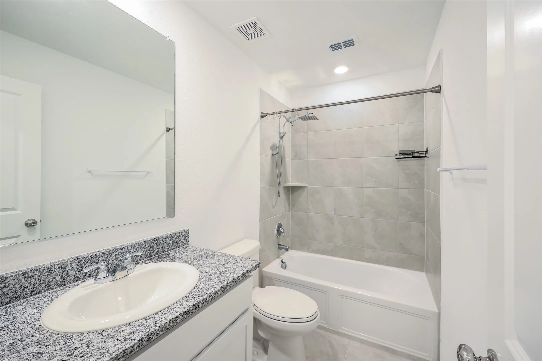 Bathroom with a granite-style countertop, oval sink, and chrome faucet