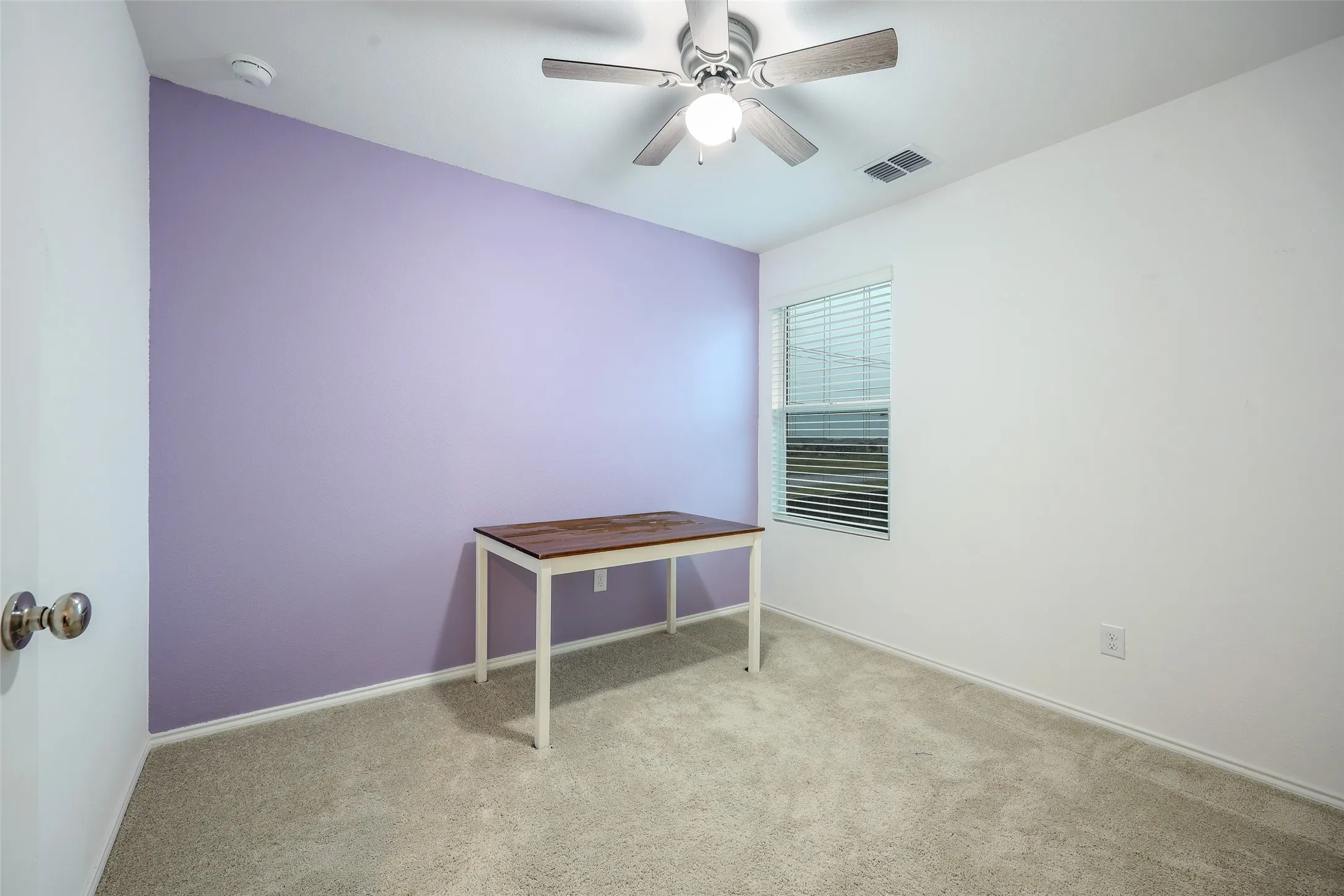 Carpeted flooring, window with blinds, ceiling fan with integrated lighting, and a smoke detector