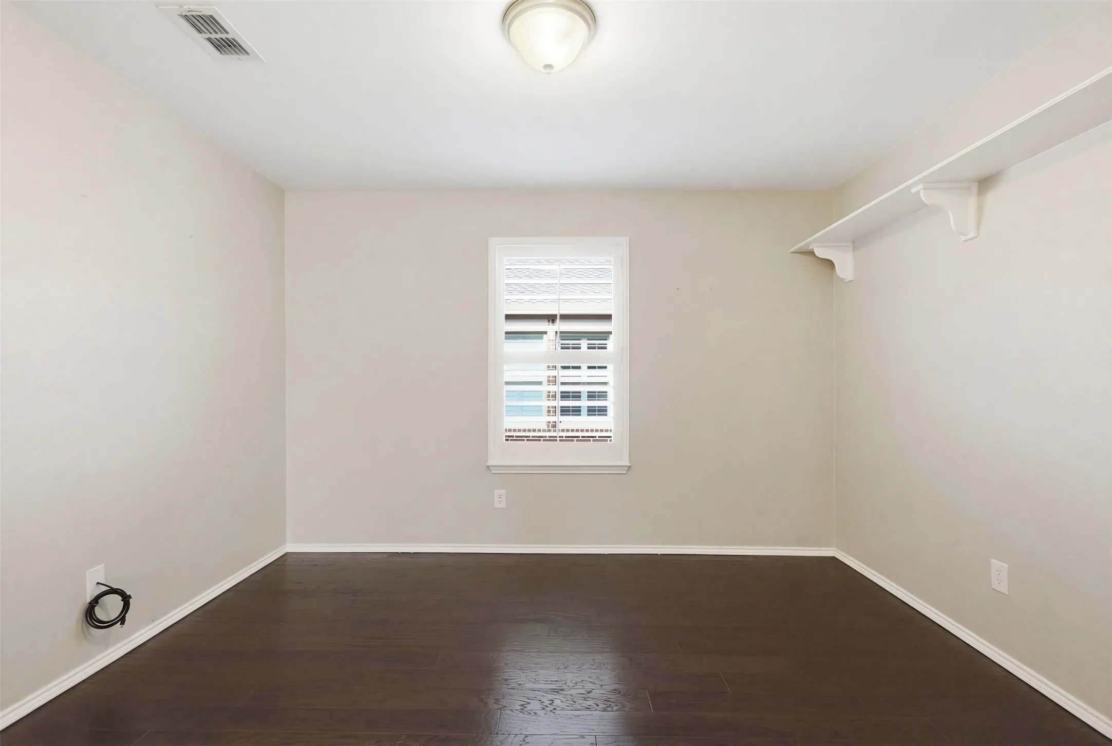 Dark wood-finish flooring with light-colored walls and white trim