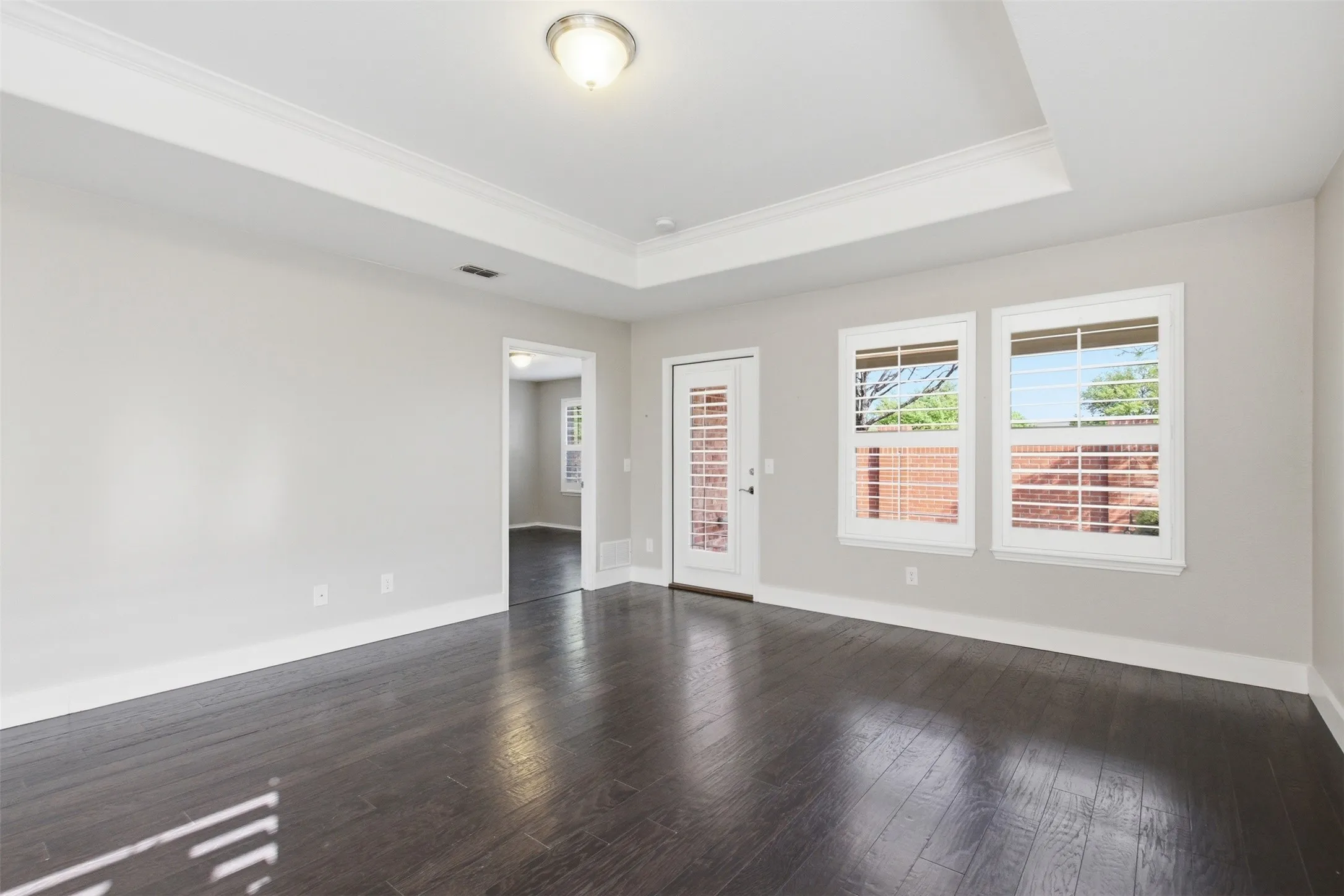 Dark wood-finish flooring with crisp white baseboards