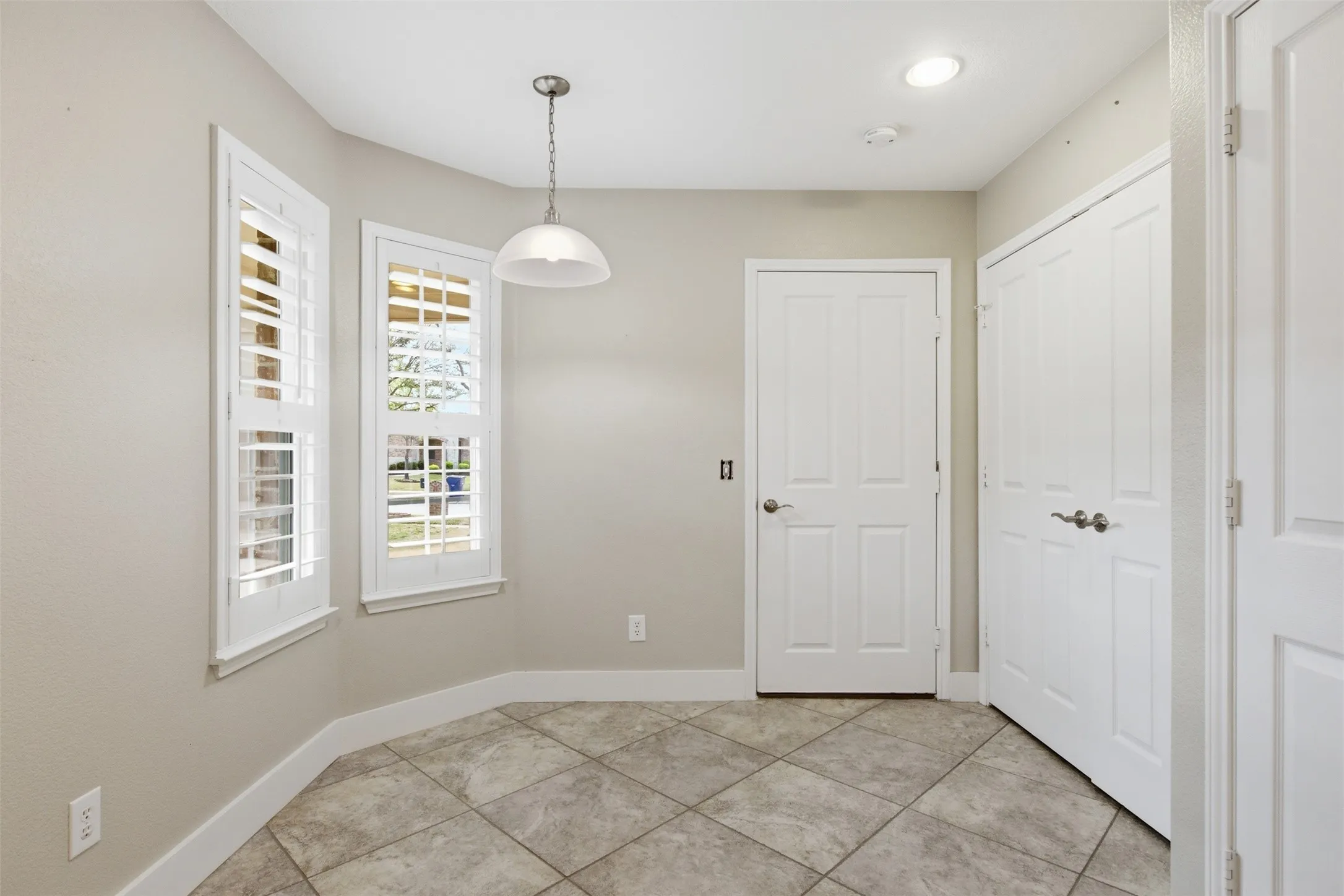Tile flooring with an angled pattern, double panel doors, recessed lighting, and a pendant light fixture