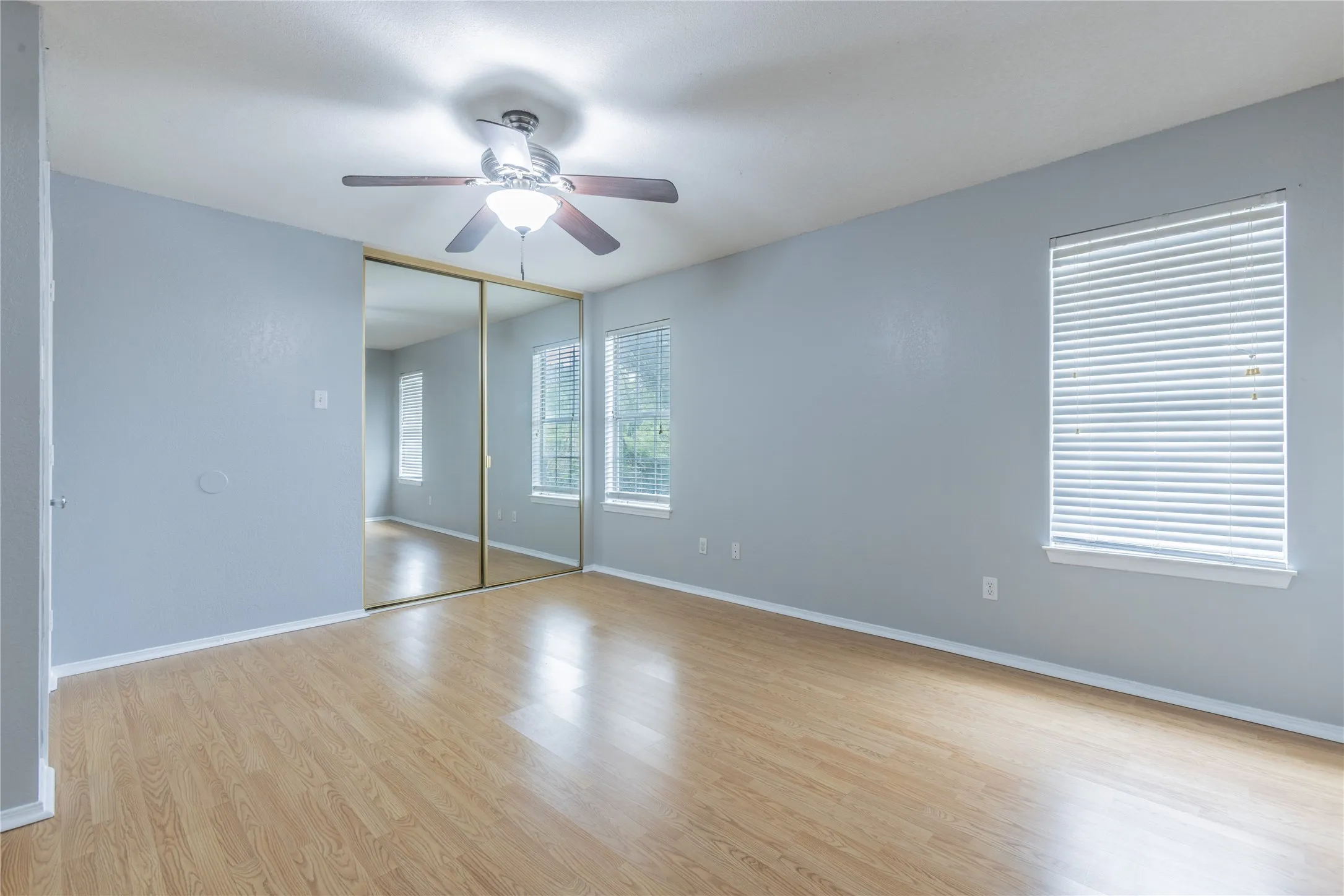 Wood-finish flooring with a ceiling fan light fixture