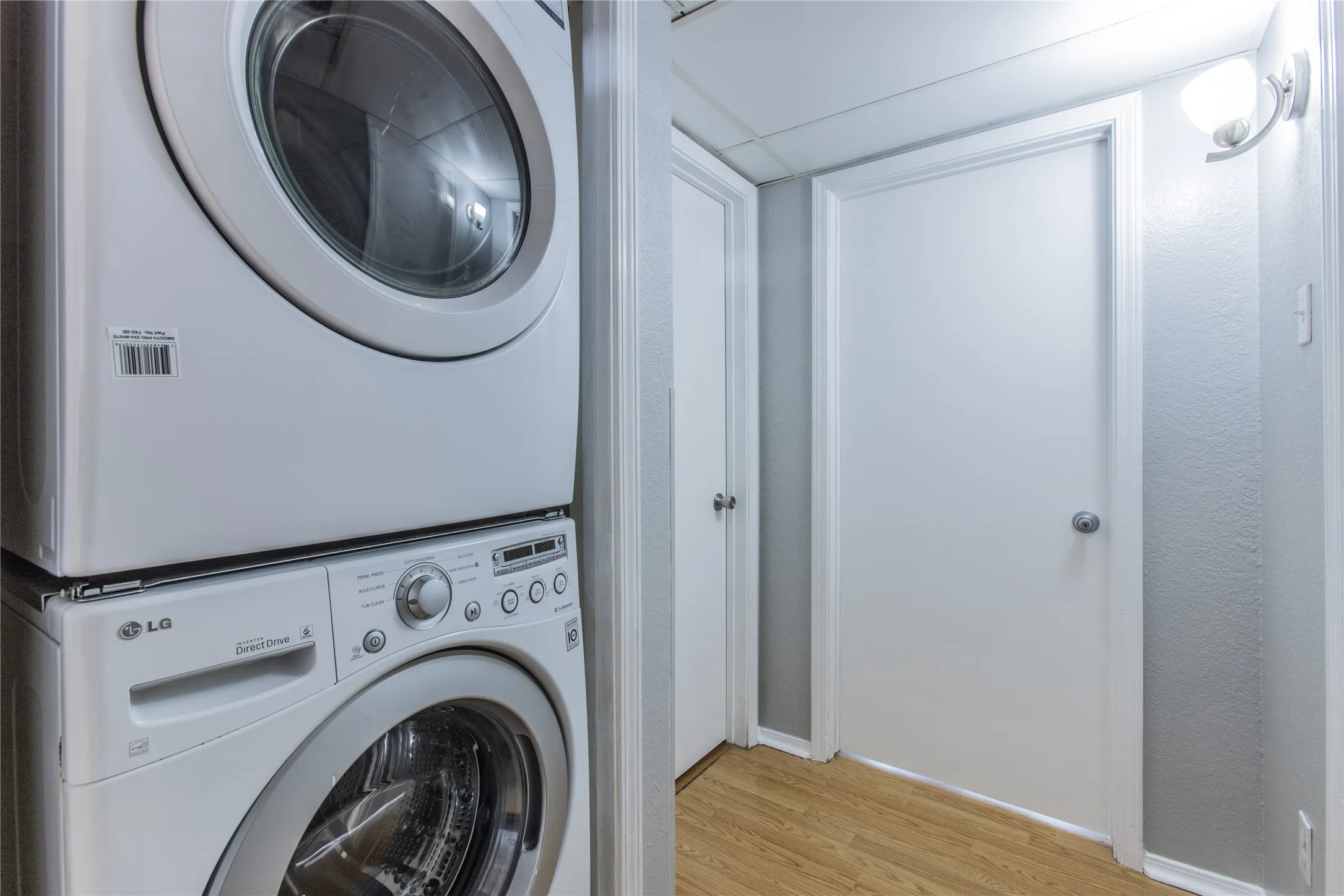 Dedicated laundry area featuring a stacked washer and dryer unit