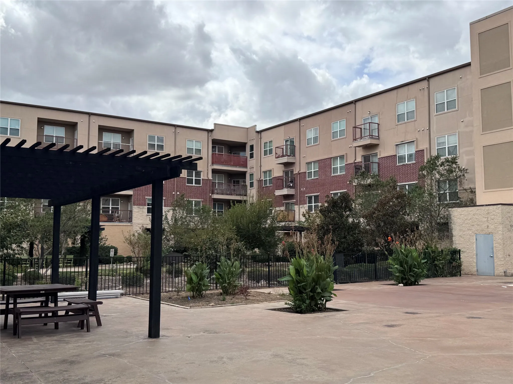 Multi-story building with a combination of brick and stucco exterior, featuring individual balconies and multiple windows