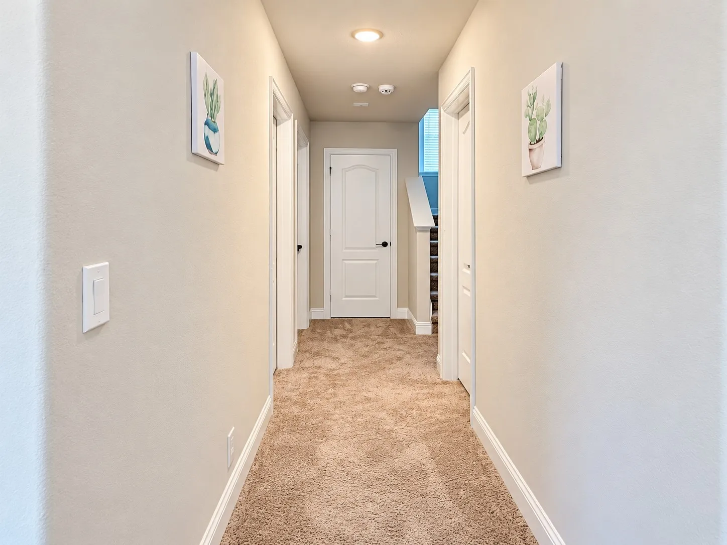 Carpeted hallway with light neutral walls, white trim, and recessed lighting