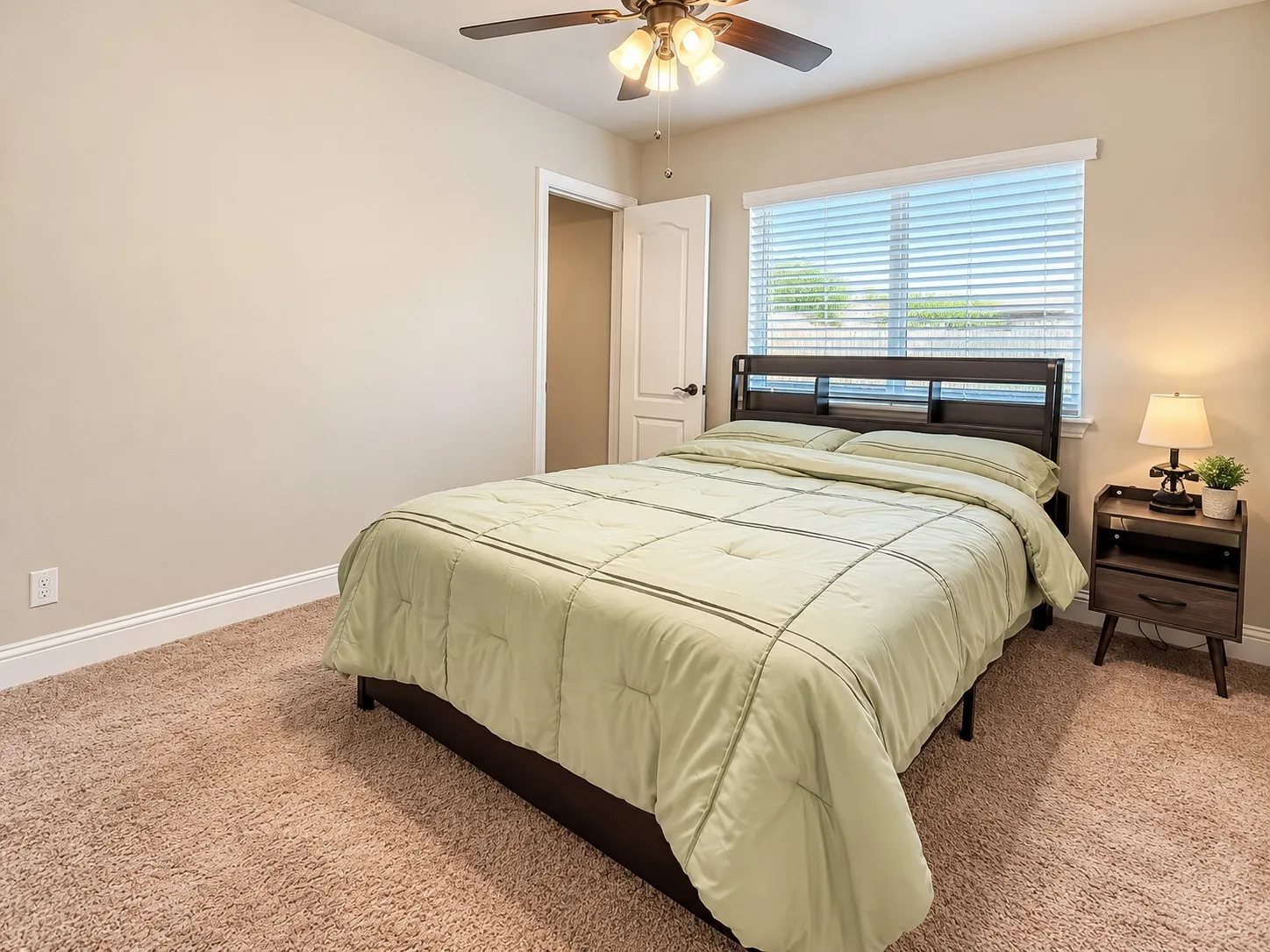 Carpeted flooring, window with blinds, ceiling fan with light fixture, and a white interior door