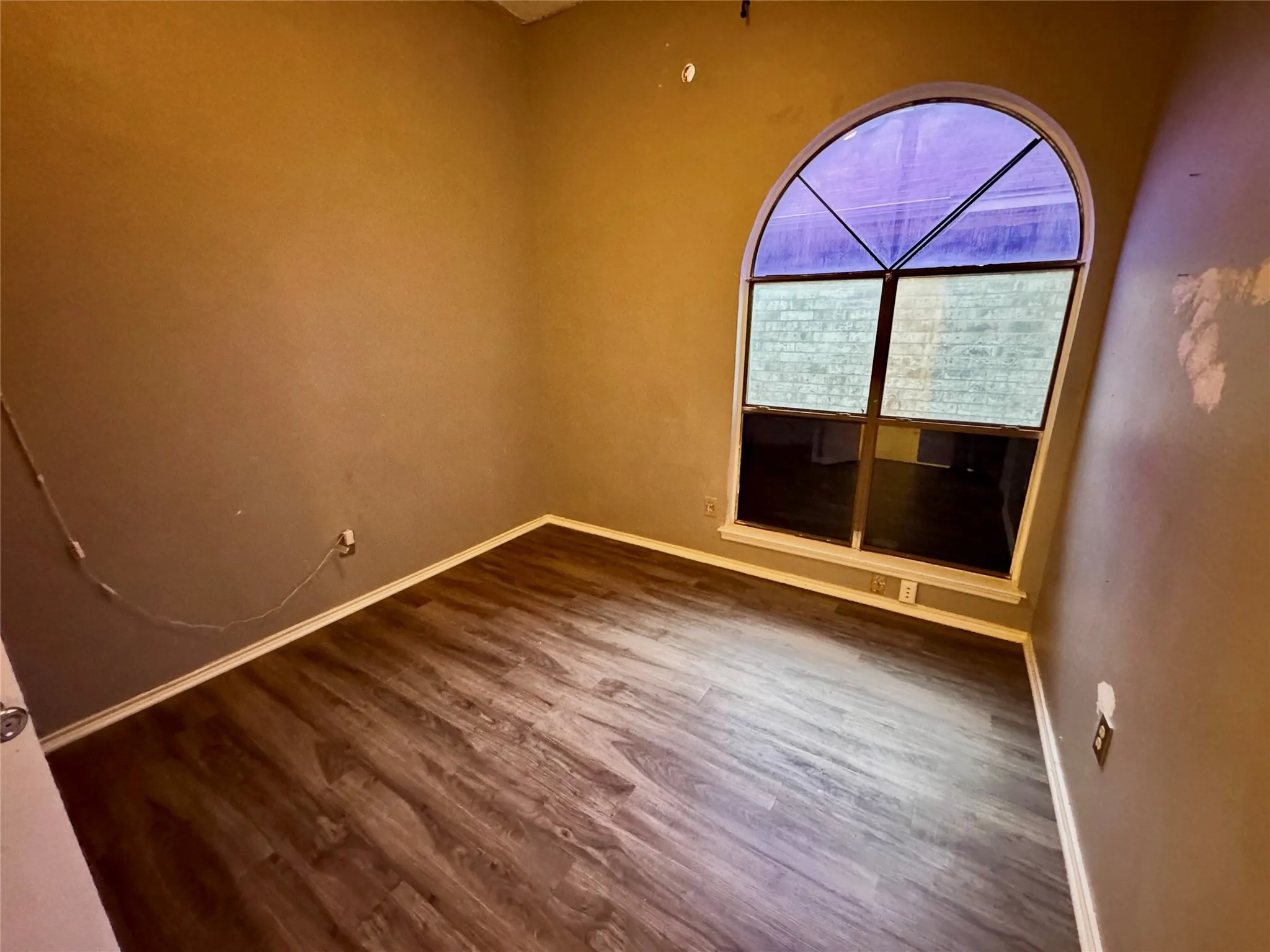 Arch-top window, wood-finish flooring, white trim details