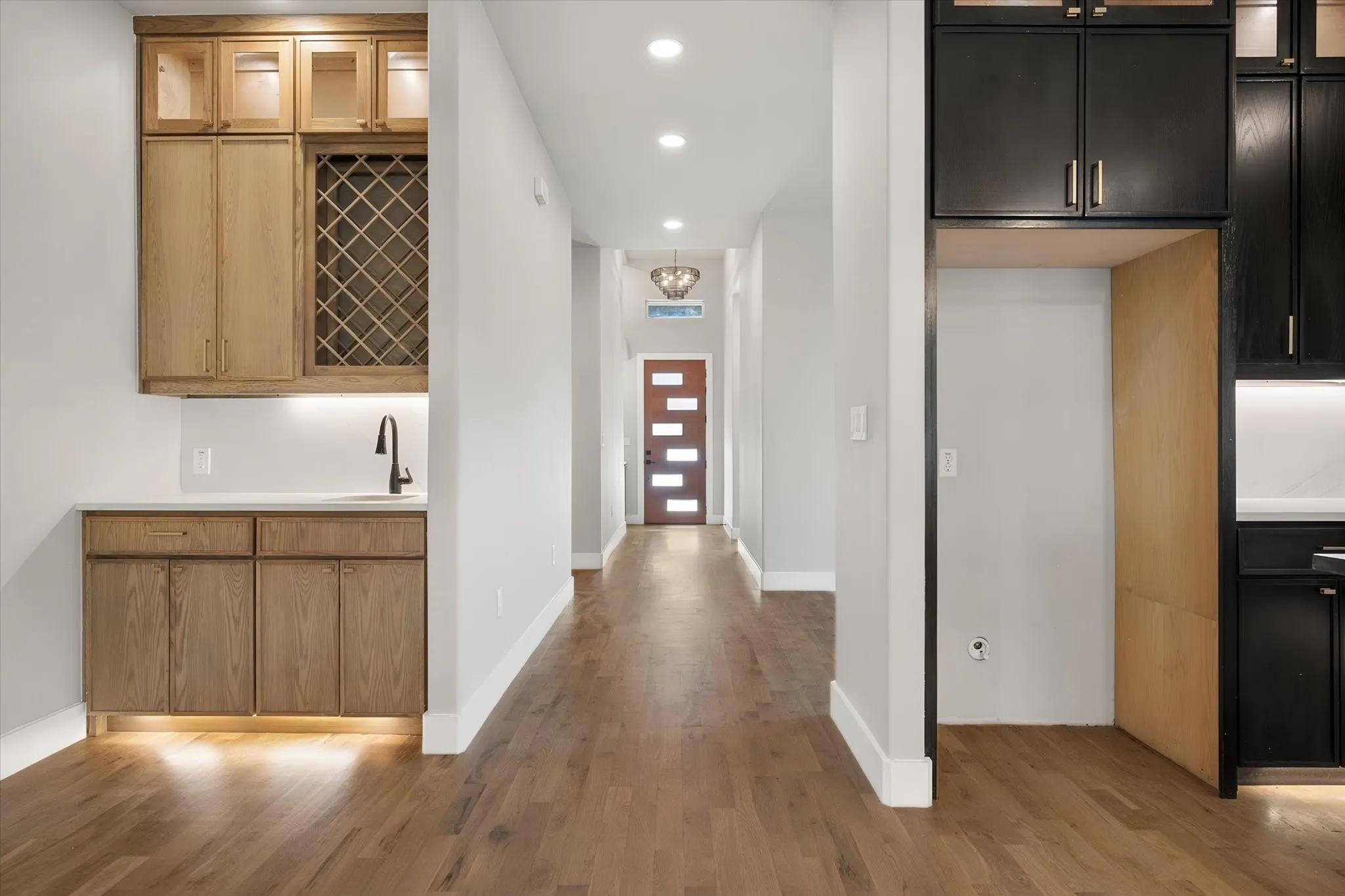 Wood-finish flooring throughout, with recessed lighting and a contemporary light fixture