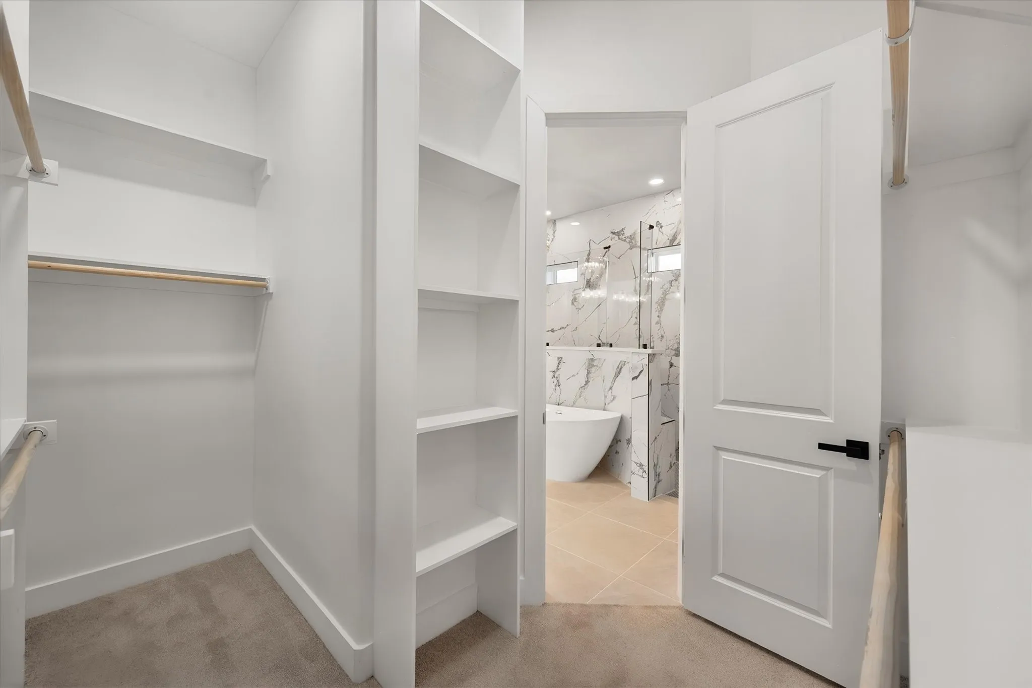 Walk-in closet with built-in shelving, hanging rods, and carpet flooring