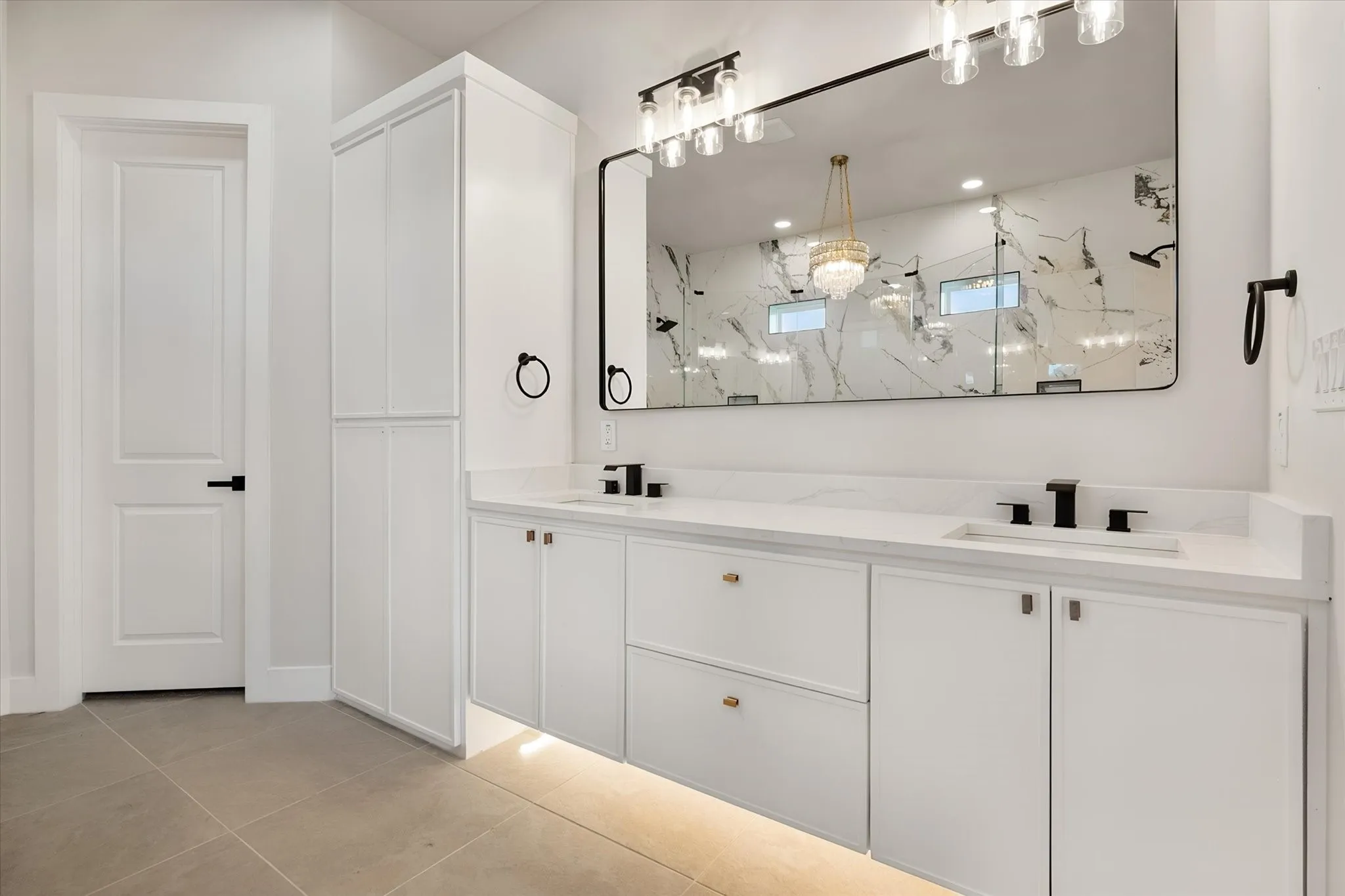 Double vanity with integrated sinks, white cabinetry, undermount lighting, and matte black fixtures