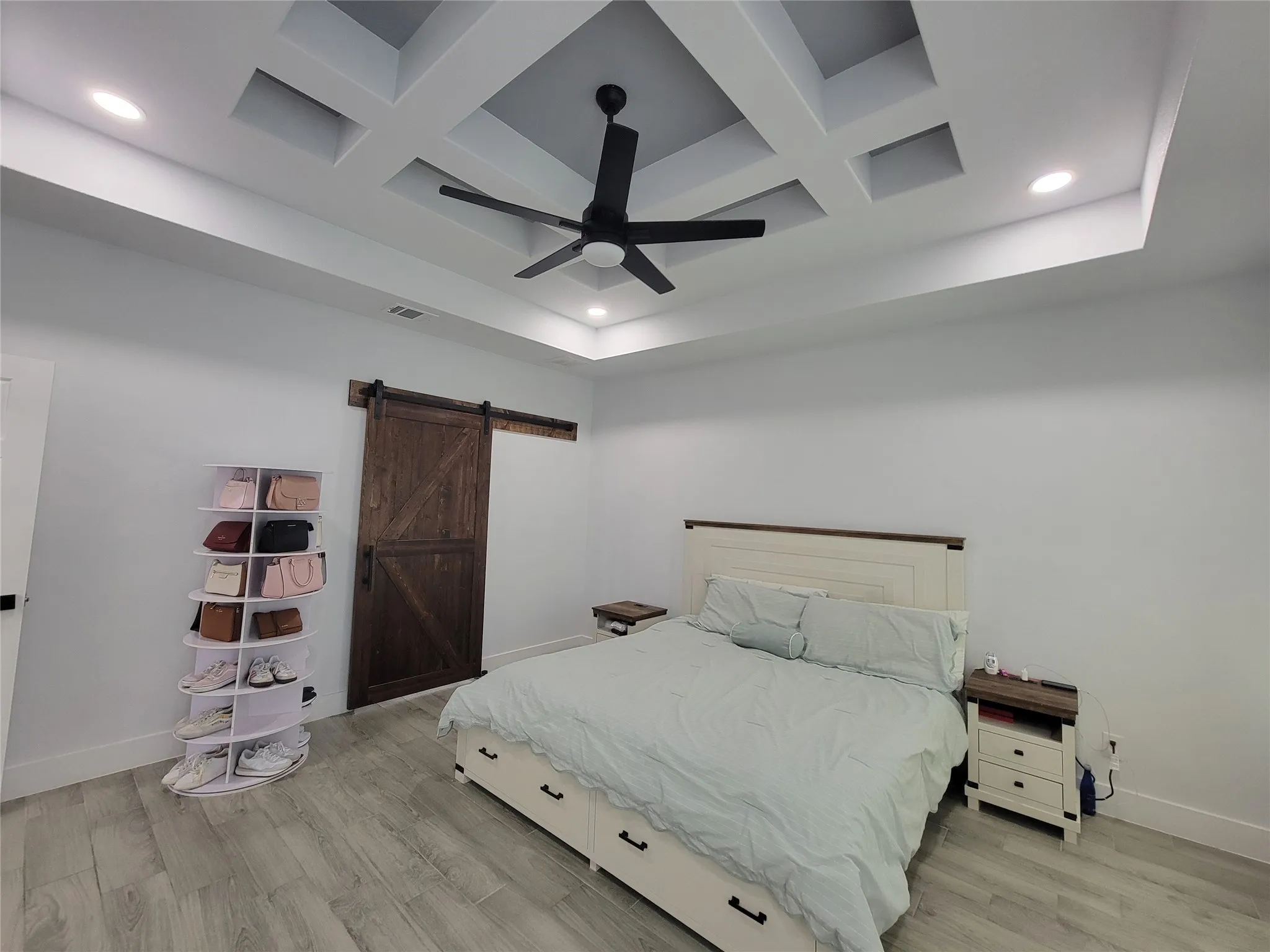 Coffered ceiling with recessed lighting and a ceiling fan, wood-finish flooring, and a barn door