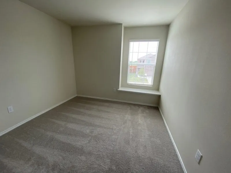 Recessed window with a sill, neutral toned walls, and light-colored carpeting