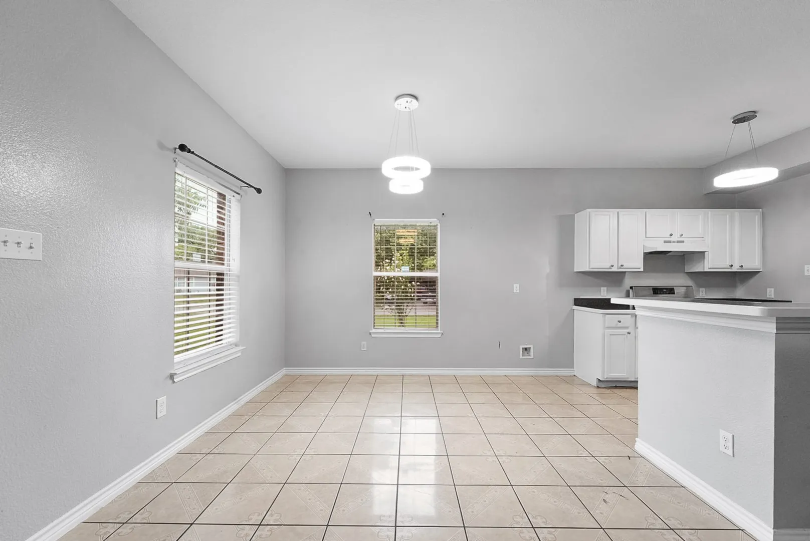 Kitchen featuring white cabinetry, dark countertops, an electric range, and a breakfast bar