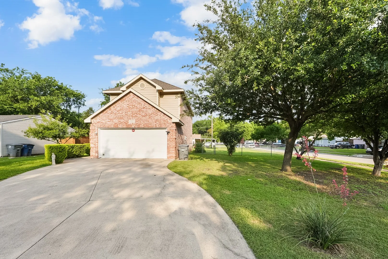 Two-story residence featuring brick and siding facade, an attached two-car garage, and a concrete driveway