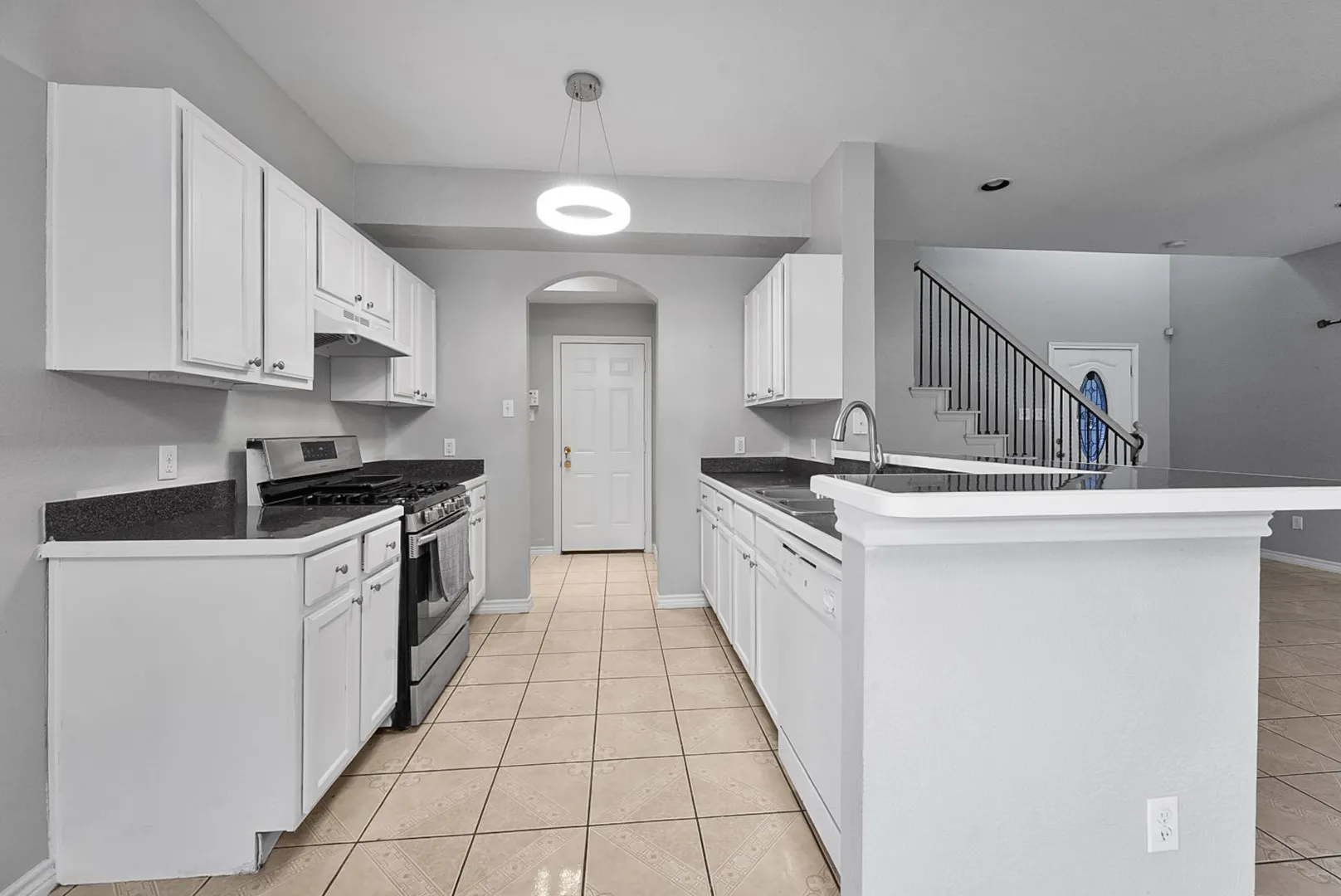 Kitchen featuring white cabinetry, dark countertops, a stainless steel range, and tile flooring