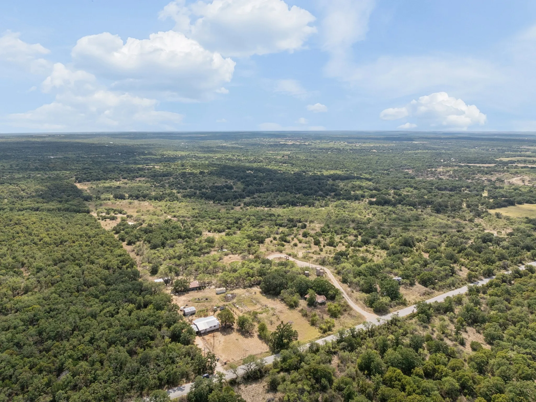 Expansive rural landscape featuring a mix of dense and scattered tree coverage