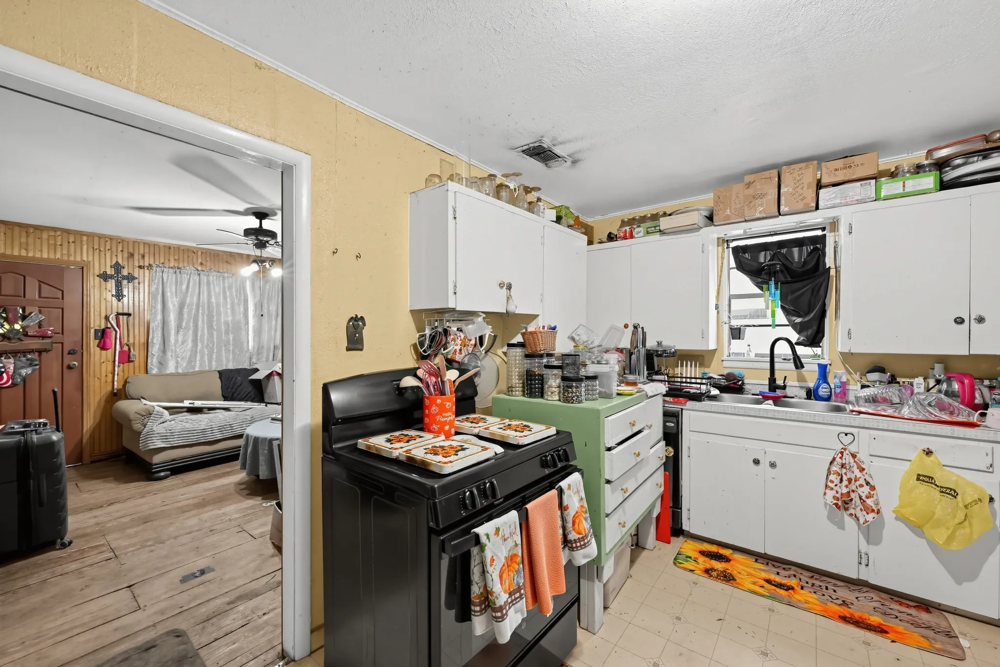 Kitchen featuring white cabinetry and a black-finish range
