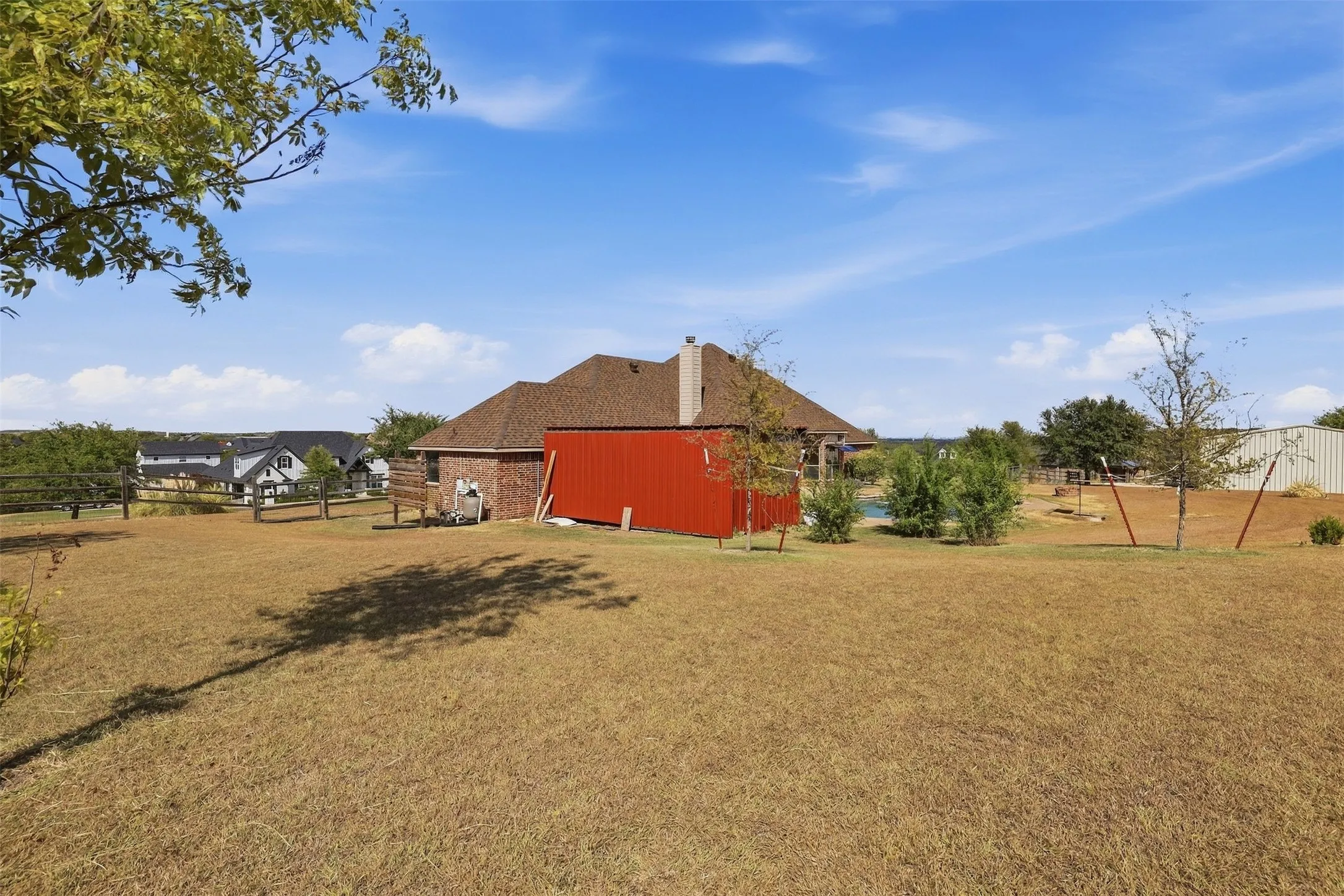 Expansive outdoor space featuring a red storage building and brick-clad architecture