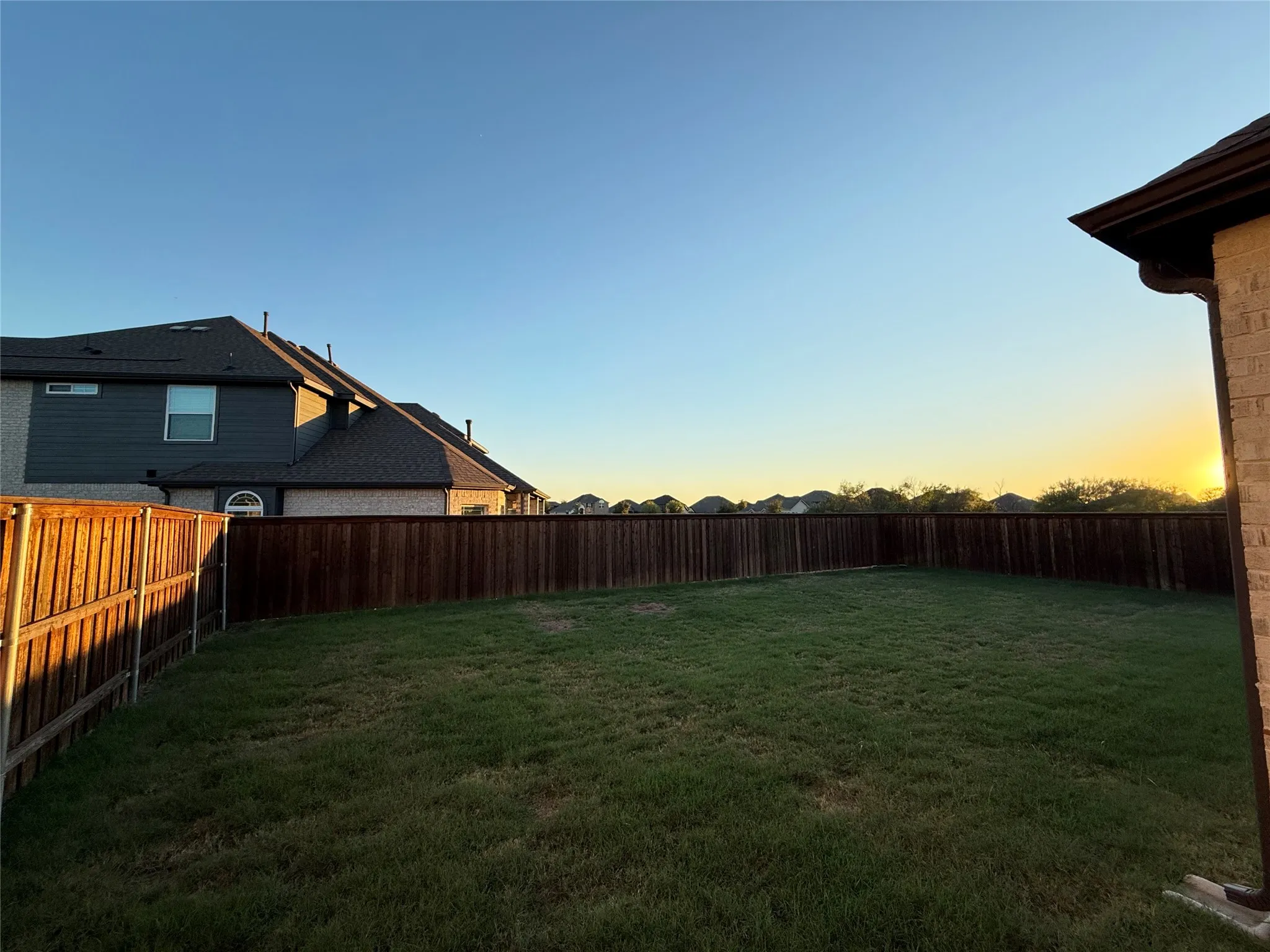 Expansive backyard featuring a full perimeter privacy fence and a large grass lawn