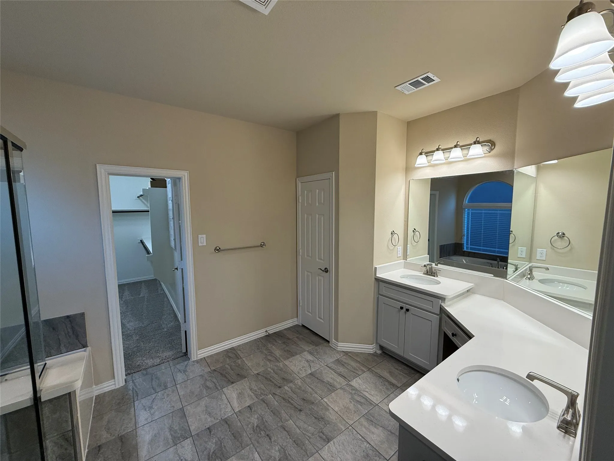 Dual vanity with integrated sinks, light-toned countertops, and brushed nickel fixtures
