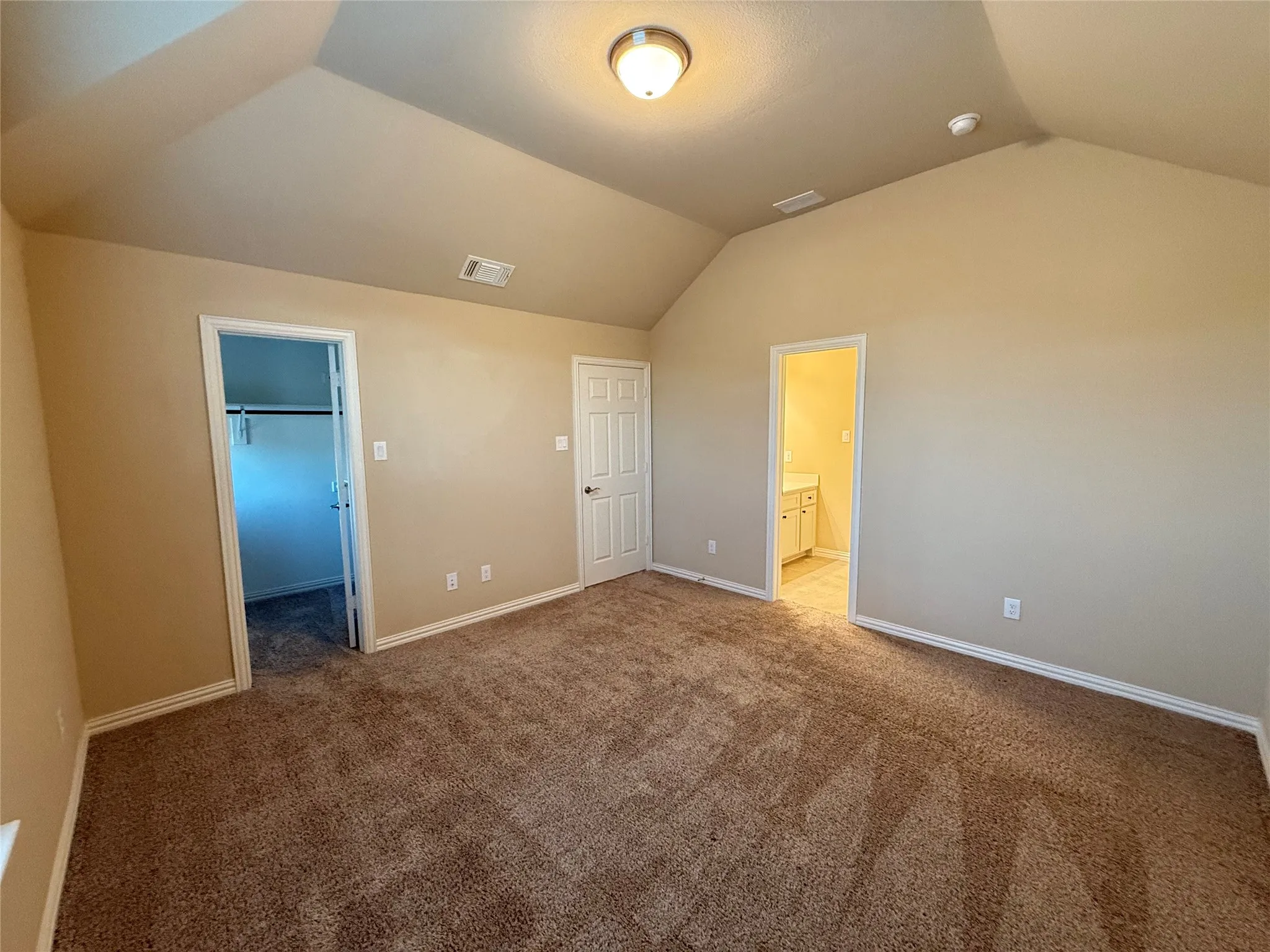 Vaulted ceiling, neutral wall paint, brown carpet flooring, flush mount lighting, white trim