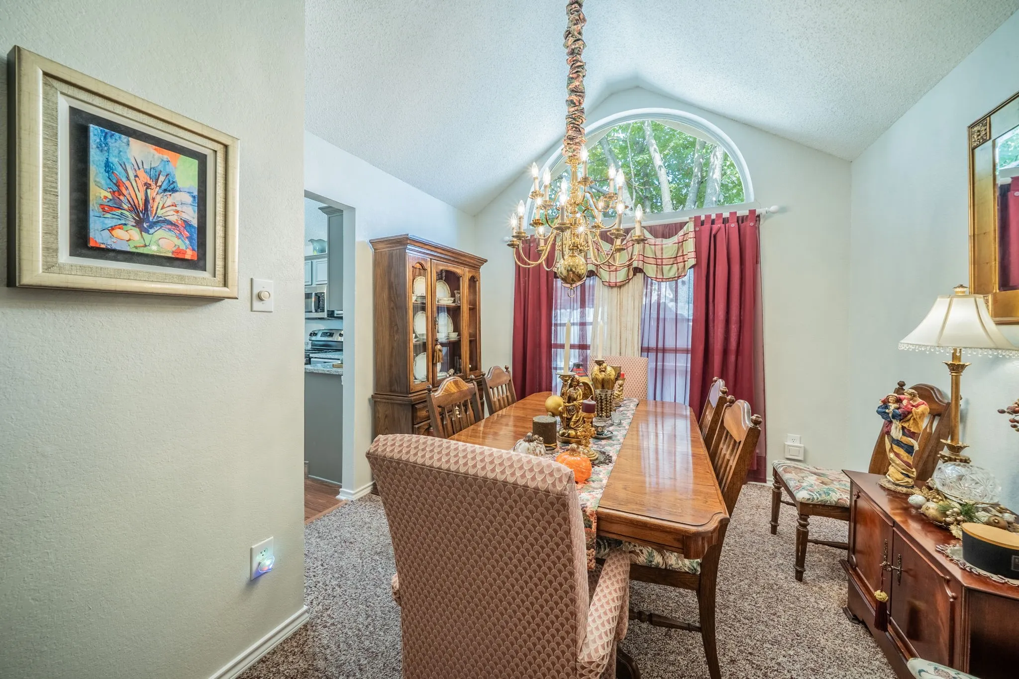 Vaulted ceiling with an arched window and a solid brass chandelier
