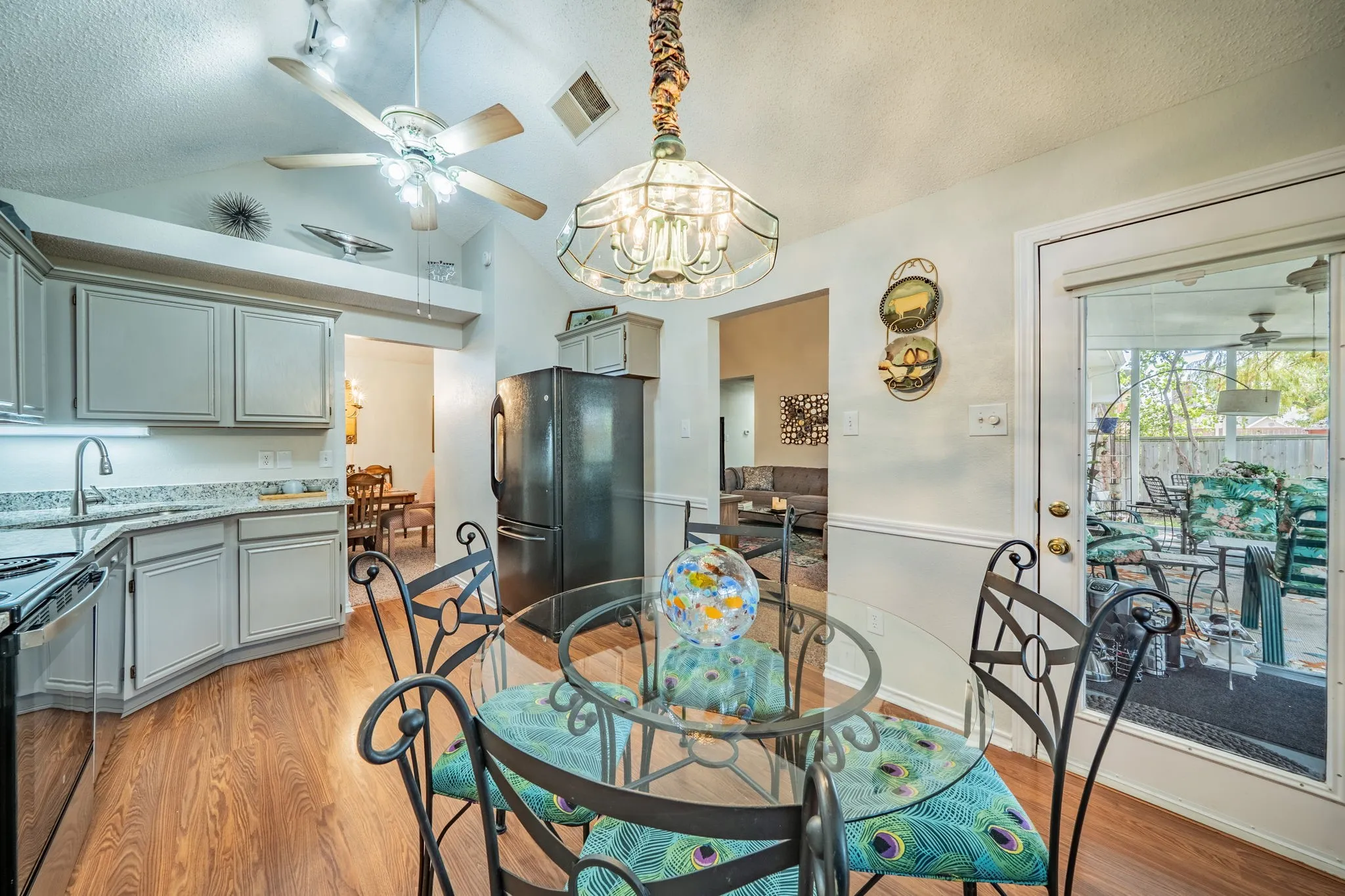 Kitchen featuring wood-finish flooring, light-toned cabinetry, and a full-light door