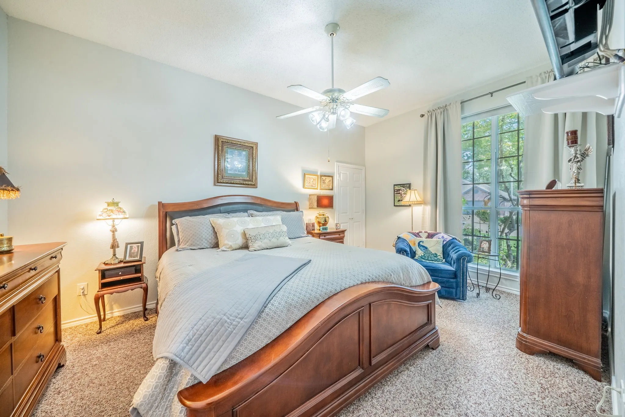Tray ceiling with crown molding, ceiling fan with integrated lighting, window with mullions, and neutral wall color