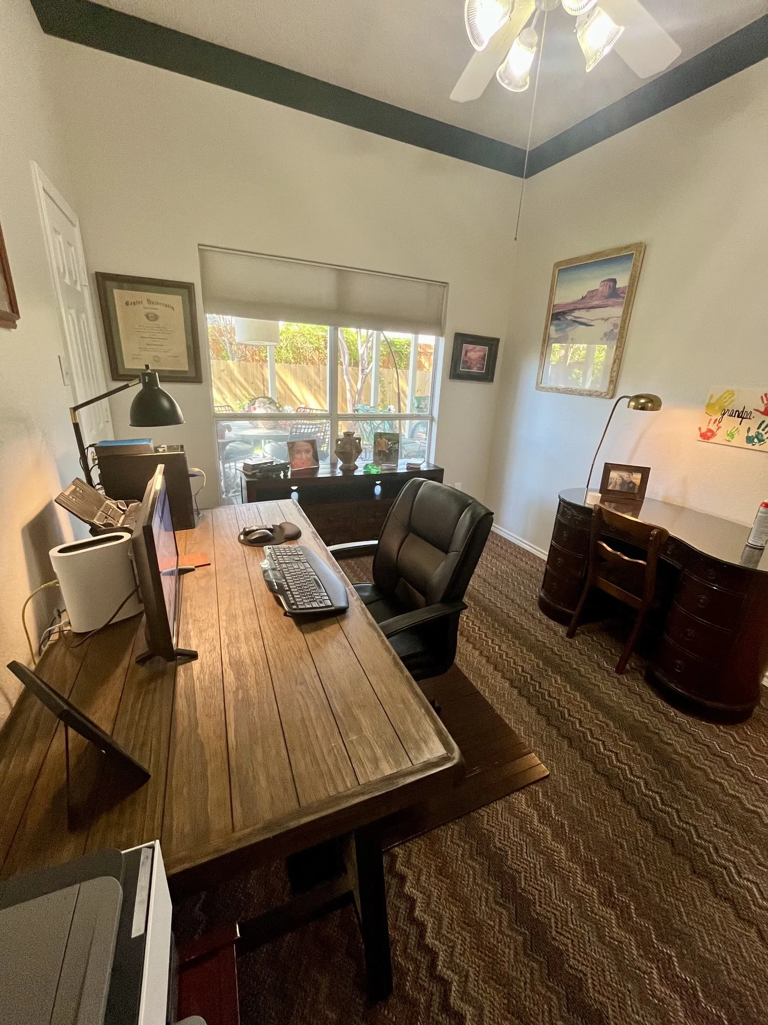 Vaulted ceiling with a ceiling fan, window with roller shade.Could be a 4th bedroom has full size walk-in closet
