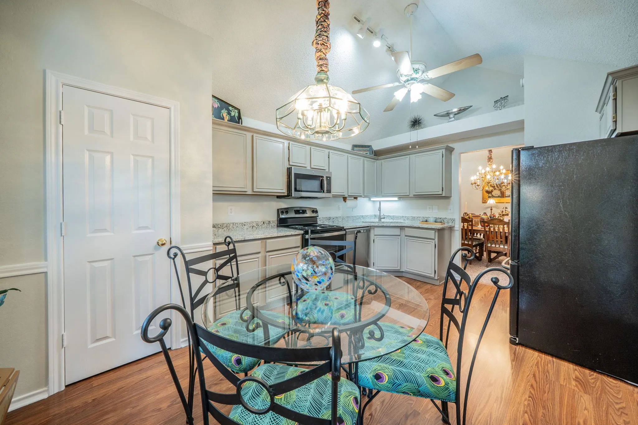 Kitchen featuring light-toned cabinetry, a built-in microwave, and wood-finish flooring
