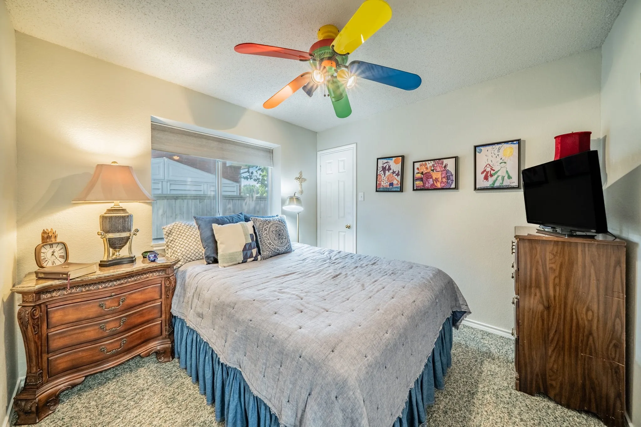  neutral finish, a window with roller shade, and a ceiling fan with colored blades