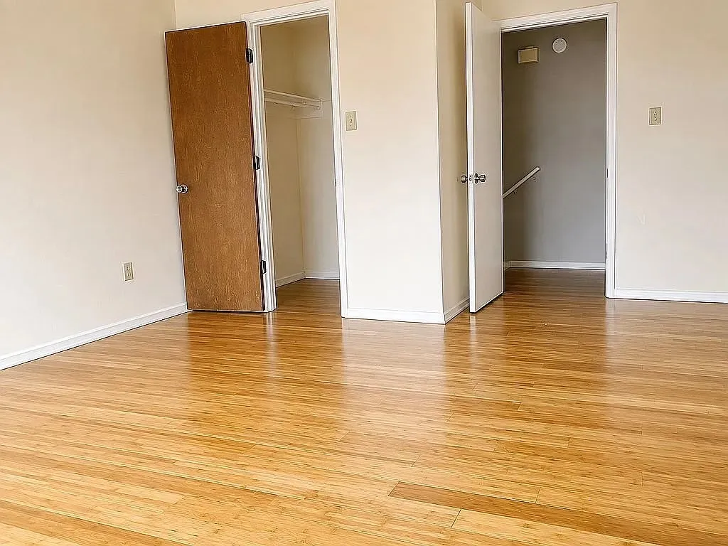 Wood-finish flooring throughout, with a built-in closet featuring a hanging rod