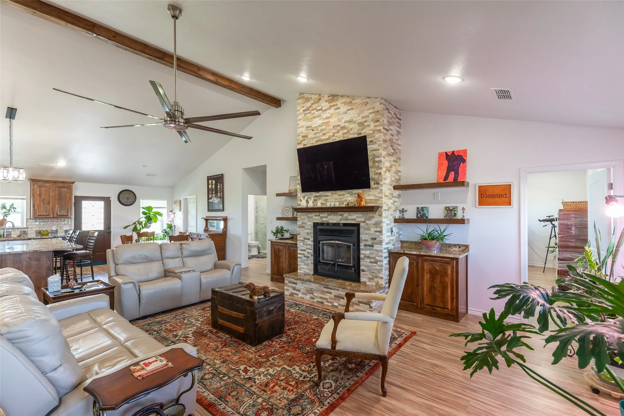 Vaulted ceiling with exposed wood beams and a large ceiling fan