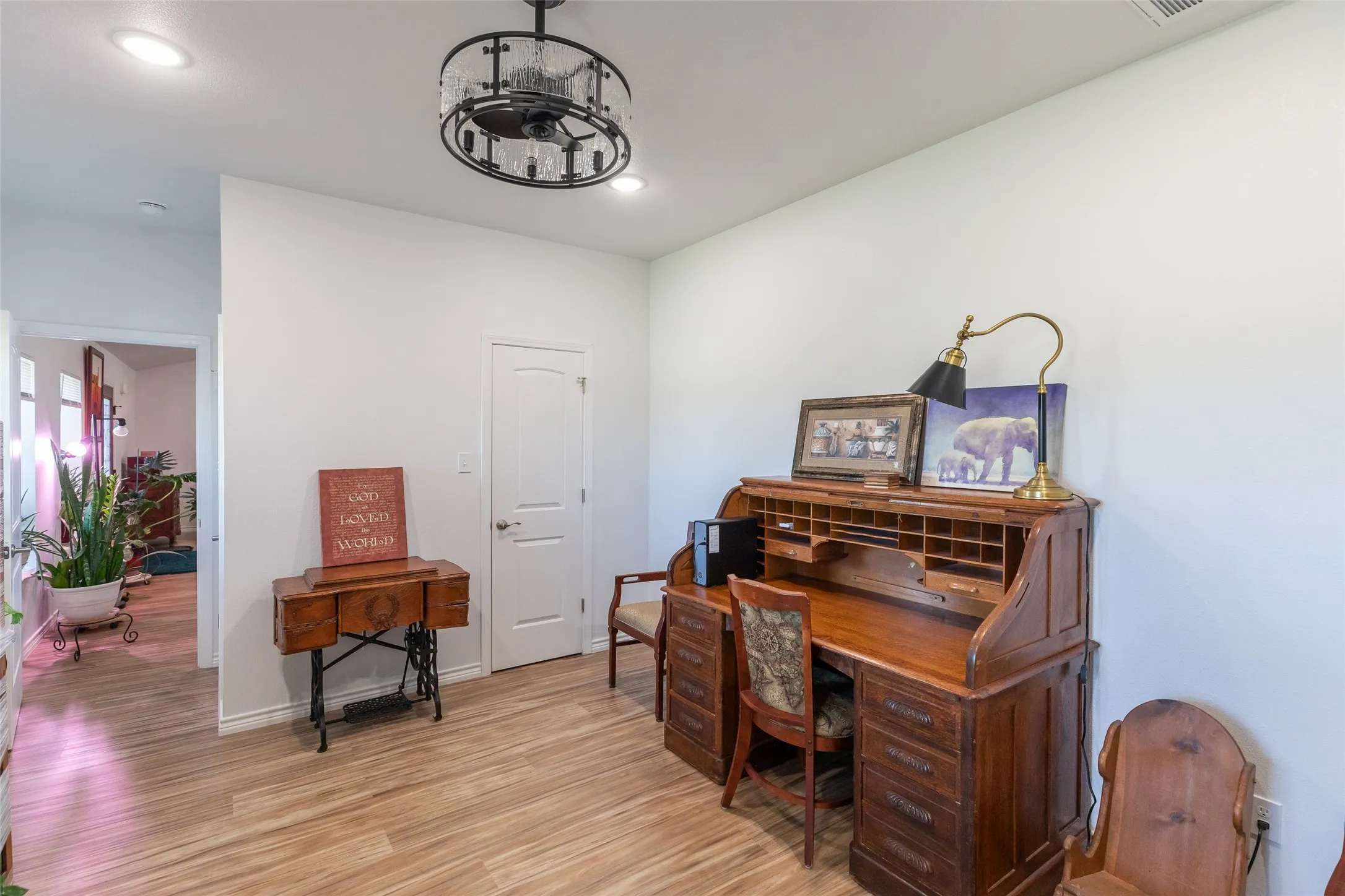Wood-finish flooring, recessed lighting, and a decorative ceiling fixture illuminate this space