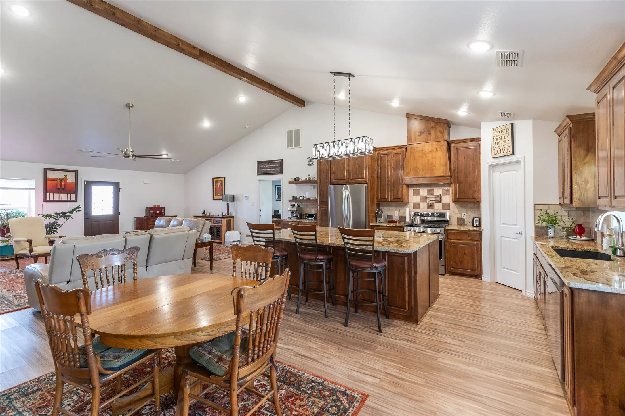 Vaulted ceiling with exposed wood beam, wood-finish flooring, recessed lighting, and a ceiling fan