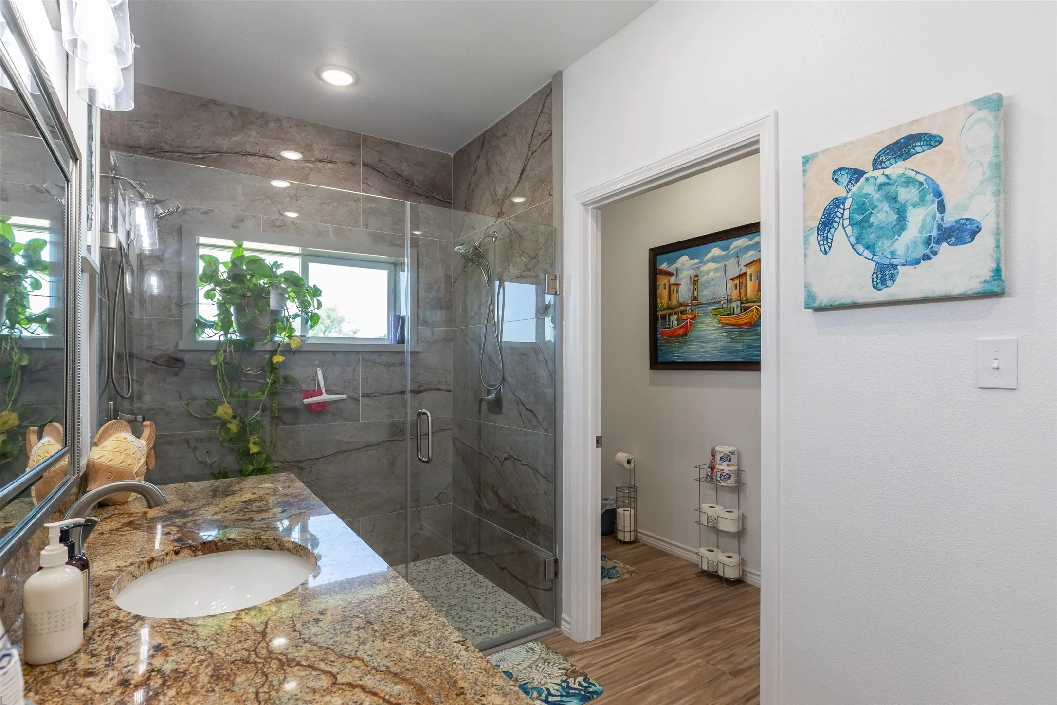 Walk-in shower with full-height stone-finish tile surround, fixed glass panel, and mosaic tile flooring