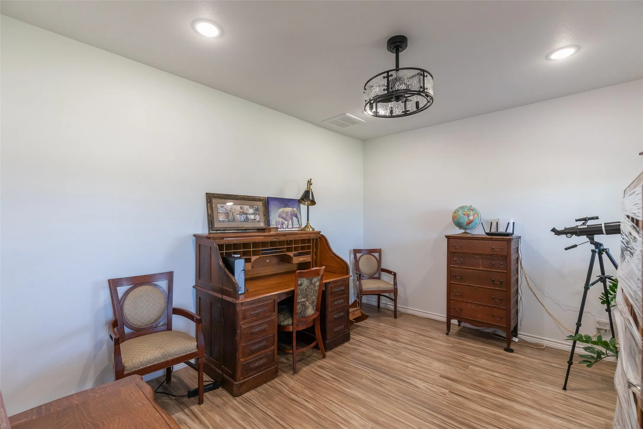 Recessed ceiling lighting, wood-finish flooring, and a decorative ceiling light fixture
