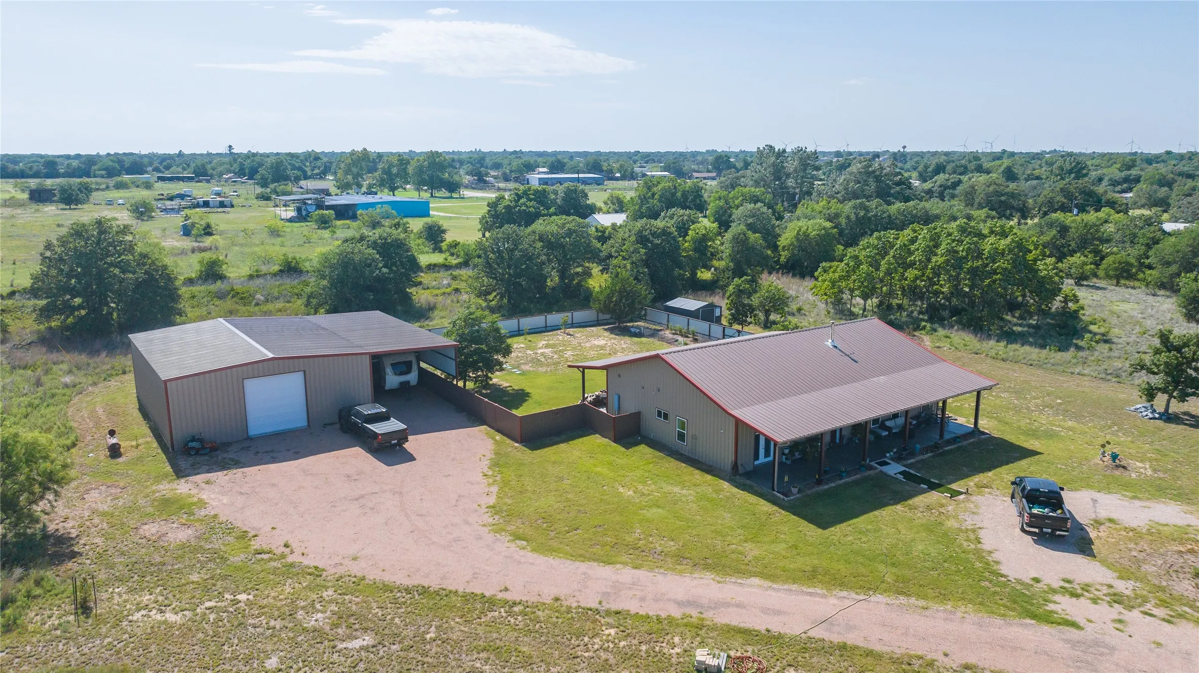 Single-story residence with a covered front porch, metal roof, and an expansive detached garage