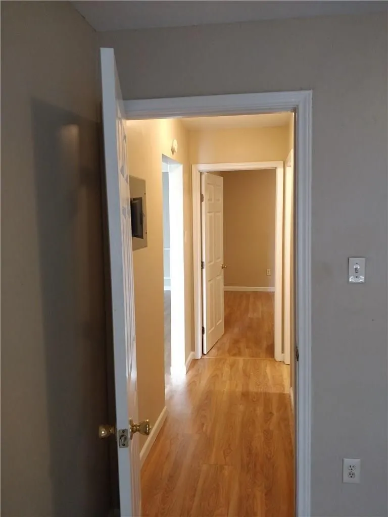 Hallway featuring wood-finish flooring and neutral wall tones