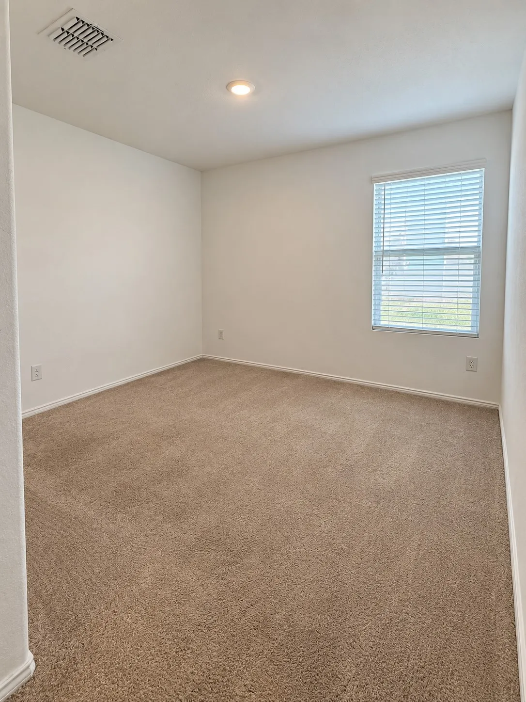 Well-sized secondary bedroom featuring neutral carpeting, recessed lighting, and a  large window for natural light.