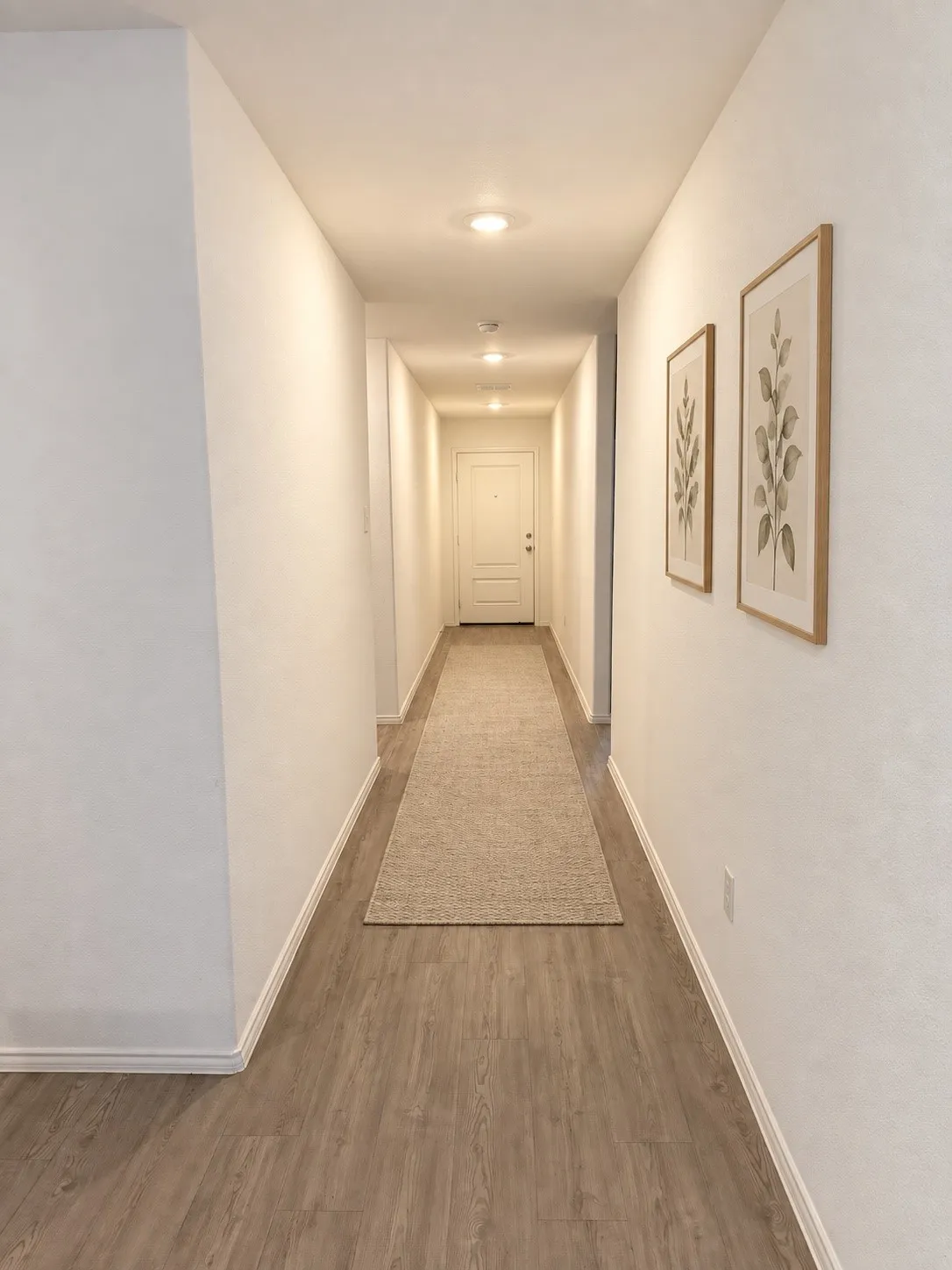 *Virtually Staged* Bright, welcoming entry hallway featuring luxury vinyl plank flooring, recessed lighting, and neutral finishes that create a clean, cohesive look.