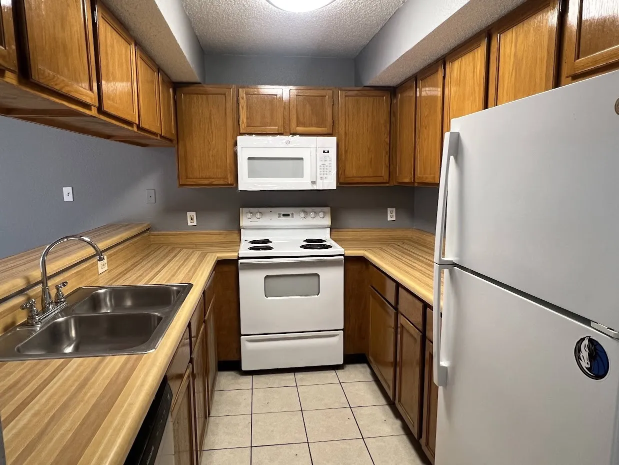 Kitchen featuring wood-finish countertops, extensive wood cabinetry, and tiled flooring